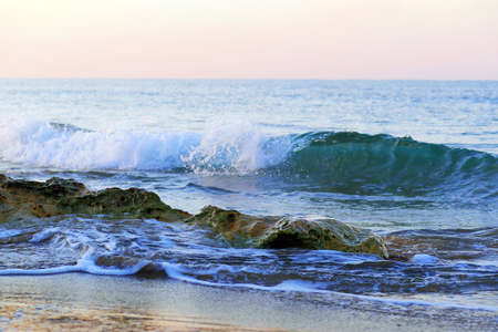 rocks at beach and rolling wave at backgroundの写真素材