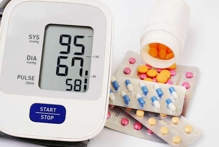 automatic blood pressure meter and pills on white backgroundの写真素材
