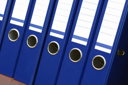 closeup of blue file binders in a row on a shelfの写真素材