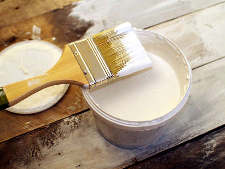 paintbrush and white paint jar on wooden table, top view, shallow depth of fieldの写真素材