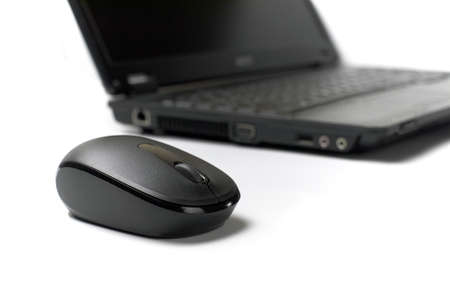 wireless mouse in front of laptop on white background