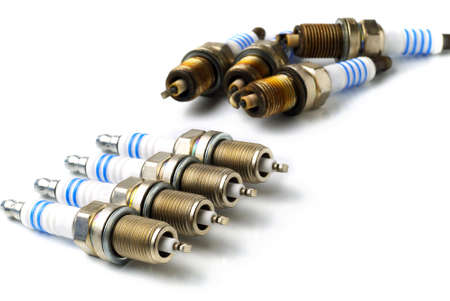 all-new and used spark plugs on white background, copy space