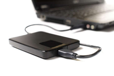 external usb disk connected to laptop on white background, shallow depth of fieldの写真素材