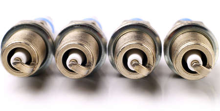 four brand new unused spark plugs on white background, suitable for header or bannerの写真素材