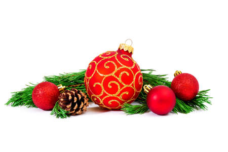 red christmas ball with green pine tree branches and cone isolated on white backgroundの写真素材