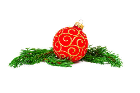 red christmas ball with green pine tree branches isolated on white backgroundの写真素材