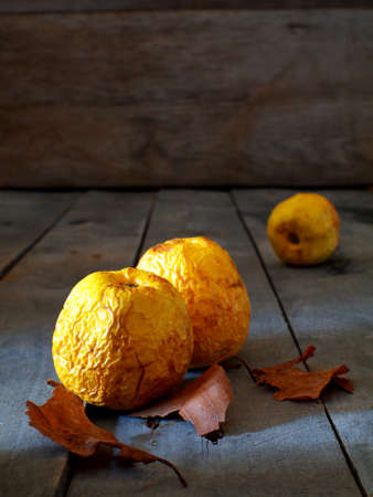 three withered apples on a wooden board with copy spaceの写真素材