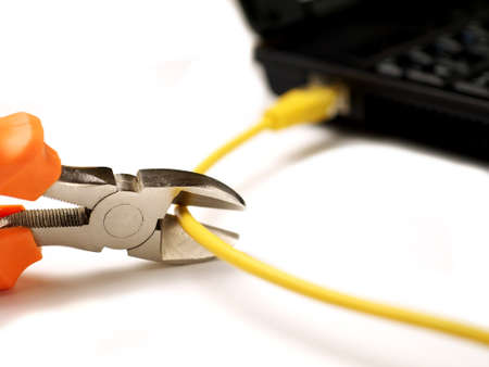 wire cutter cutting network cable from laptop on white background, shallow depth of field, selective focusの写真素材