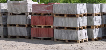 stacks of paving slabs on pallets in storage outdoors