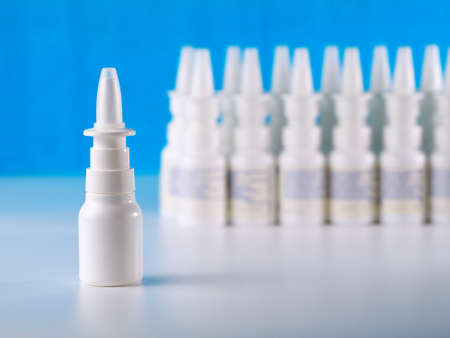 nasal spray bottle in front of other bottles row, shallow depth of field, advertisement conceptの写真素材