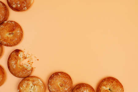 frame composed of round shortcake brown cookies with crumbs on yellow background