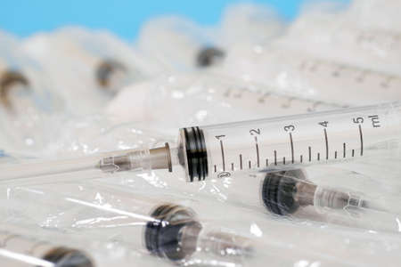 closeup of plastic disposable syringe on a blister pack of syringes