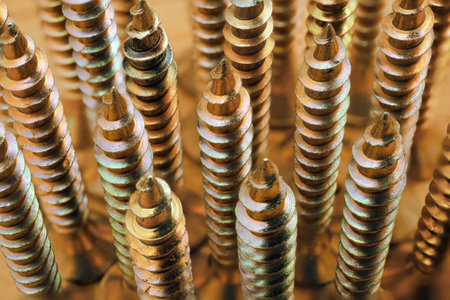 macro of yellow zinc coated screws, abstract industrial backgroundの写真素材