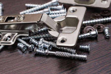 Closeup of various furniture fittings. Furniture assembly kit,  Concealed hinge and various screws.の写真素材
