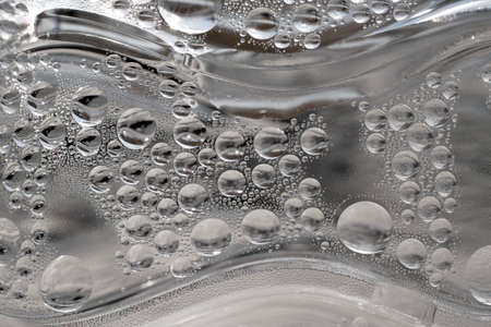 Macro of condensed round water droplets plastic bottle. Abstract background with circles and waves.