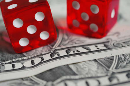 closeup of two red dice on dollar banknoteの写真素材