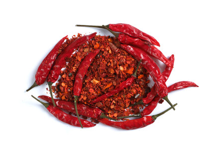 top view on heap of ground dried chili pepper flakes and whole pods isolated on white backgroundの写真素材