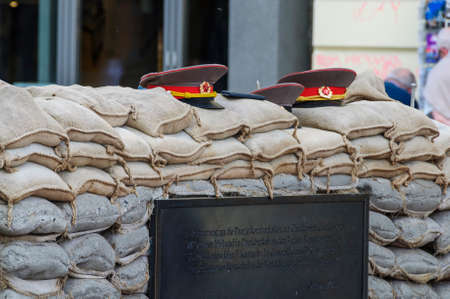 Russian military hats resting on a sandbag wall at Checkpoint Charlieのeditorial素材