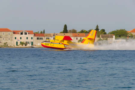 SIBENIK, CROATIA, August 6 2012 - Bombardier 415 Superscooper (Canadair cl-415) scooping water in tight channel near Sibenikのeditorial素材
