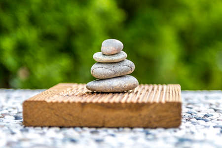 Zen stones on wood with green backgroundの写真素材