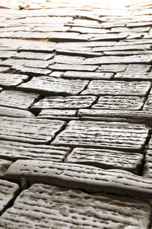 Ancient medieval street paved with cobblestones with carvings to prevent slipperyの写真素材
