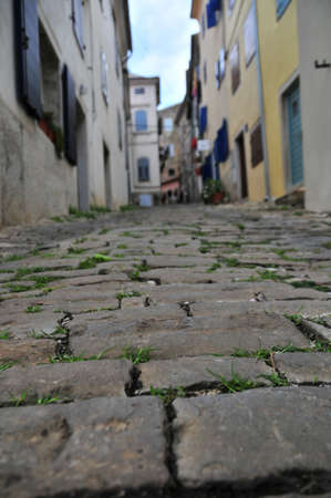Detail of street stone pavement in a medieval town, houses and buildings in background out of focus for effectの写真素材