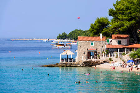 Bol, Croatia - July 7 2016: Beach bar & Restaurant Ribarska kucica in Bol, island of Brac. Famous beach Zlatni rat in backgroundのeditorial素材