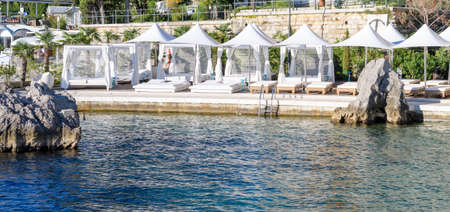 Luxury resort private beach with beds, mattresses and white sunshadesのeditorial素材