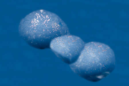 Beautiful micro air bubbles captured in water drops and frozen in ice sparkle in the sun. Closeup...