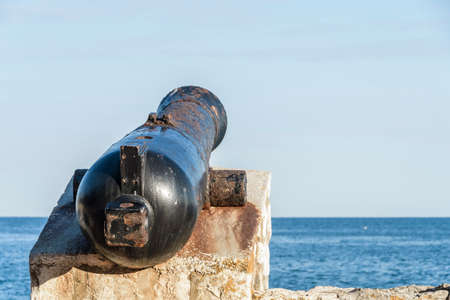 Ancient old cannon on coastal fortress walls aiming to the sea; fortress defenseの写真素材