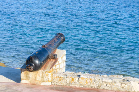 Ancient old cannon on coastal fortress walls aiming to the sea; fortress defenseの写真素材