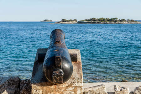 Ancient old cannon on coastal fortress walls aiming to the sea; fortress defenseの写真素材