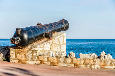 Ancient old cannon on coastal fortress walls aiming to the sea; fortress defenseの写真素材