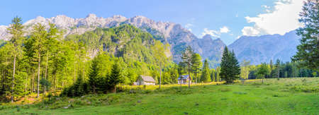 A beutiful landscape in the mountains, clouds above peaks and forest in foregroundの写真素材
