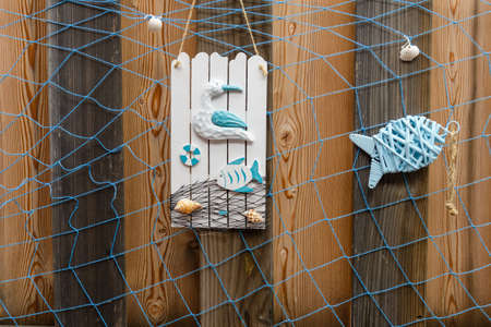 Summer beach style decoration with shells, seagull and fish on weathered wooden backgroundの写真素材