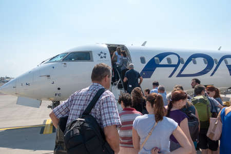 Ljubljana, Slovenia - August 25 2018: Passengers board Adria Airways Bombardier CRJ-900 passenger jet at Ljubljana Airport to SKopje. Adria is local carrier connecting short flights to the Balkans.のeditorial素材