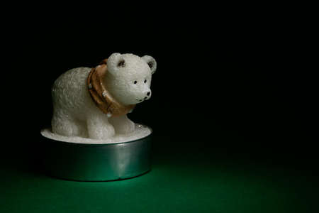 Cute polar bear figurine on dark green background, interior and Christmas decoration, isolatedの写真素材