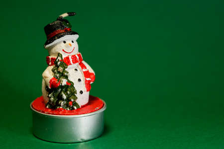 Snowman figurine isolated on green background, Christmas decoration concept, interior designの写真素材
