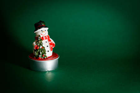 Snowman figurine isolated on green background, Christmas decoration concept, interior designの写真素材