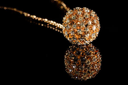 Feminine golden bracelet with shiny gems close up macro on plain black background, fashion accessoiresの写真素材