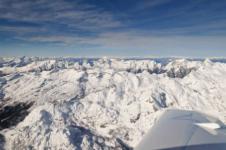Flying above Mount Triglav in Julian Alps in winter, aerial landscape panorama of mountains covered with snow, highest mountain in Slovenia, Austrian Alps in backgroundの写真素材