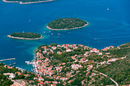 Aerial view of smaal town with harbor on the Adriatic coast in Croatia, sailing boats in harbor, emerald blue sea, vacation and tourism conceptの写真素材