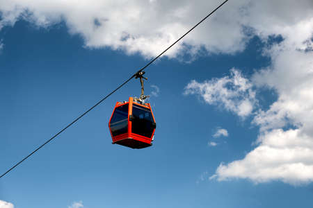 Single red cable car on cableway isolated on blue sky, overhead cableway car of Pohorska vzpenjaca in Maribor, Sloveniaの写真素材