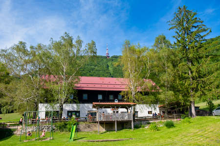 Poljcane, Slovenia - June 09 2019: Mountain hut on Boc near Poljcane, Slovenia, with mountain top and radio antenna in the background, a popular hiking destination in eastern Sloveniaのeditorial素材