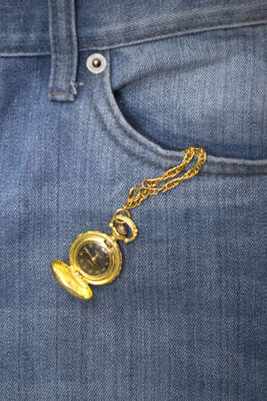 Gold watch in a denim jeans pocketの写真素材