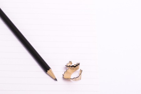 Lead pencil with sharpener and shavings on a white background