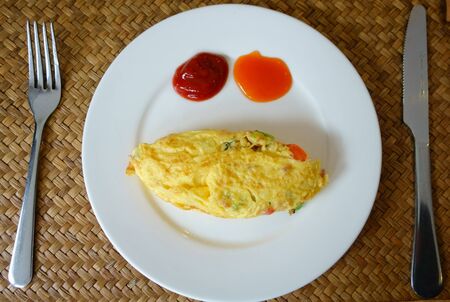 Omelette with Kerchup Sauce in White Plate. Delicious Breakfast.の写真素材