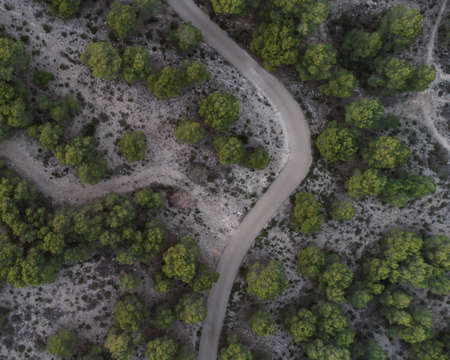 drone view of a road surrounded by trees on a mountain, landscape for wallpaperの写真素材