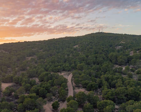 drone view of a road surrounded by trees on a mountain, landscape for wallpaperの写真素材
