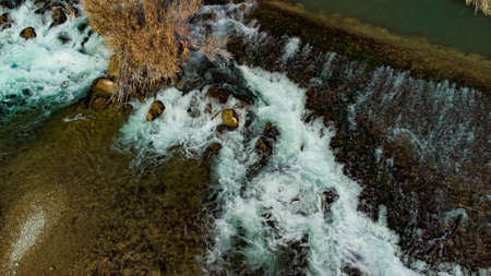 small waterfall in the riverbed of the Segura River, seen from a drone from an overhead shot in Murciaの写真素材